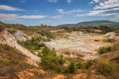 Eski kapalı taş ocağı. Eski bir taş ocağında su birikintisi. Ukrayna 'daki dağlarda eski kapalı bir taş ocağının içinde fıtık orogeninin jeolojik yapıları üzerinde büyüyen ağaçlar.