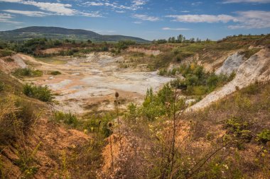 Eski kapalı taş ocağı. Eski bir taş ocağında su birikintisi. Ukrayna 'daki dağlarda eski kapalı bir taş ocağının içinde fıtık orogeninin jeolojik yapıları üzerinde büyüyen ağaçlar.