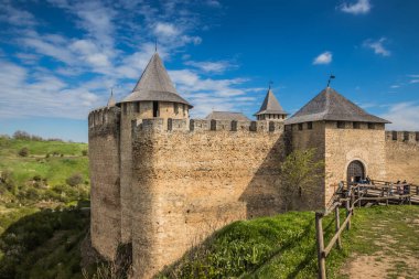 Hotin Kalesi 'nin nehir kenarındaki manzarası. Khotyn Kalesi - Sarı sonbahar tepelerindeki ortaçağ kalesi. Ukrayna, Doğu Avrupa. Orta Çağ 'ın mimarisi..
