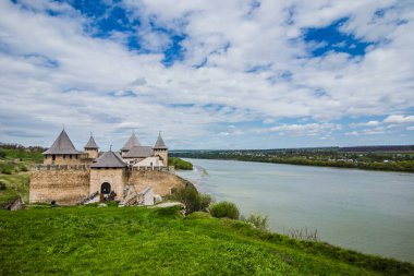 Hotin Kalesi 'nin nehir kenarındaki manzarası. Khotyn Kalesi - Sarı sonbahar tepelerindeki ortaçağ kalesi. Ukrayna, Doğu Avrupa. Orta Çağ 'ın mimarisi..