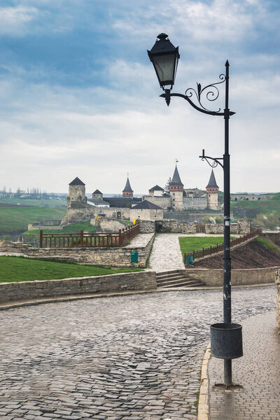 Old Kamianets-Podilskyi Castle under a cloudy grey sky. The fortress located among the picturesque nature in the historic city of Kamianets-Podilskyi, Ukraine