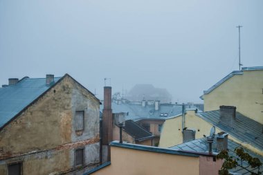 Siste eski bir kasaba. Lviv 'de sisli bir sabahta çatılar dolusu ev. Siste eski evler. Ukrayna.