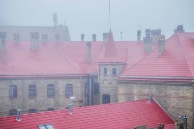 Siste eski bir kasaba. Lviv 'de sisli bir sabahta çatılar dolusu ev. Siste eski evler. Siste kırmızı çatılı bir itfaiye istasyonu. Ukrayna.