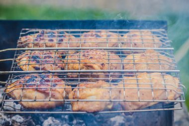 Bir tavuk kızartılıyor, önemli miktarda duman çıkıyor. Bu pişirme işlemi genellikle barbekü ve dışarıda ızgara yapmakla ilişkilendirilir.