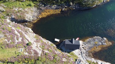 Norveç Denizi. Deniz kıyısındaki kayalar. Güzel deniz suyu. Mavi gökyüzü ve güzel güneş ışınları