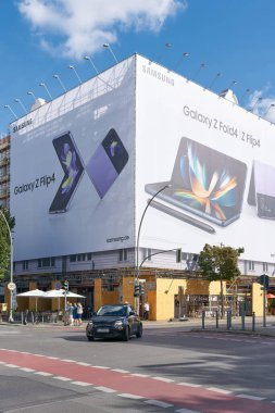  Berlin, Almanya 10 Eylül 2022: Berlin 'de Kantstrasse' de sokak sahnesi. Arka planda bir akıllı telefon reklamı var..                               