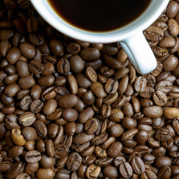 テーブルの上に焙煎したコーヒー豆とコーヒーカップ — ストック写真