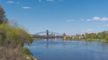      Silhouette of the city of Magdeburg on the river Elbe with Magdeburg Cathedral and Sternbrucke bridge in the foreground                          