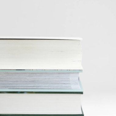 three thick books on a table with a white background                               