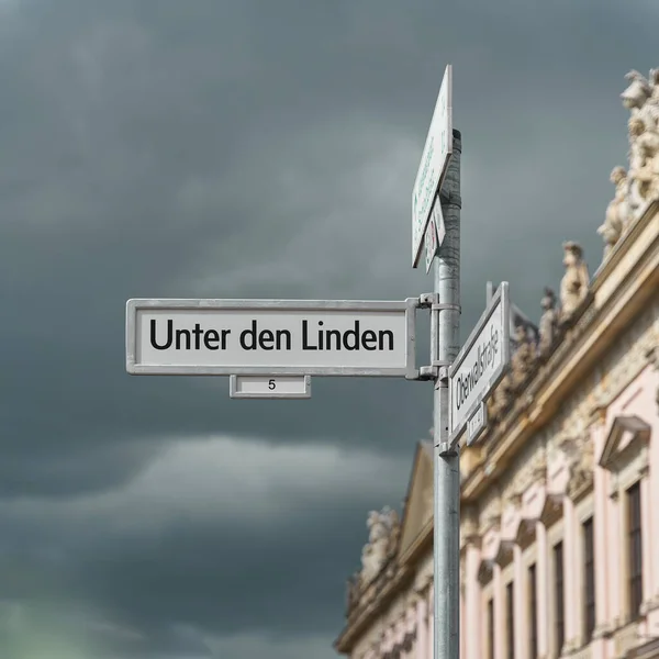 ベルリンのUnter Den Linden通りの標識 ドイツ歴史博物館を背景に 街路樹の下の通り — ストック写真
