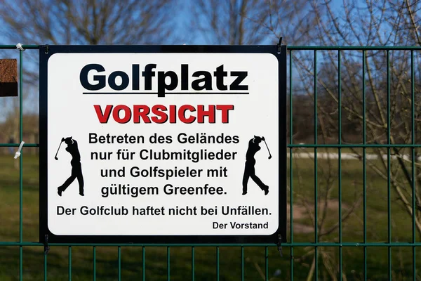 Sign at a golf course with the german inscription Vorsicht, betreten des Gelndes nur fr Clubmitglieder. Translation: Caution, entering the premises only for club members. The golf club is not liable for accidents.