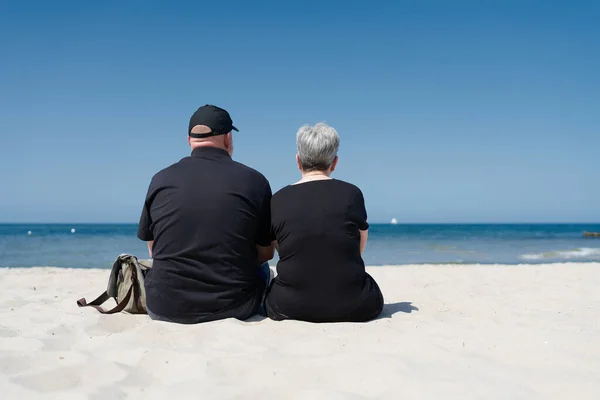 夫妻二人坐在波罗的海Kuehlungsborn附近的海滩上共度暑假 图库图片