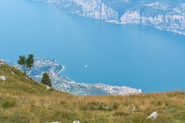 Monte Baldo 'nun tepesinden aşağıdaki Malcesine kasabasına ve İtalya' daki mavi Garda Gölü 'ne nefes kesici bir manzara.                               