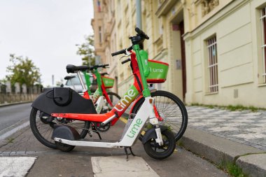 Prag, Çek Cumhuriyeti, Ekim 04, 2023: Çek Cumhuriyeti 'nin Prag şehir merkezinde Lime şirketinin e-scooter ve bisikletini park etti.                               