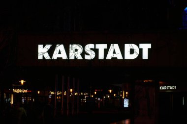 Magdeburg, Germany  February 24, 2024: Illuminated sign of the Galeria Karstadt Kaufhof group in the city center of Magdeburg in Germany in the evening                                clipart