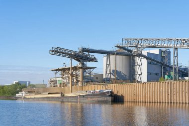 Magdeburg, Almanya 18 Nisan 2024: Magdeburg limanında bir gemiye kolza tohumu yağı eklenmesinin bir yan ürünü olan kolza tohumu yiyeceği yükleme                               