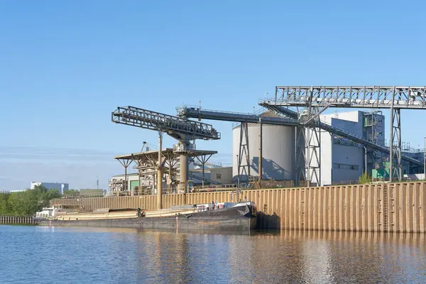 Magdeburg, Almanya 18 Nisan 2024: Magdeburg limanında bir gemiye kolza tohumu yağı eklenmesinin bir yan ürünü olan kolza tohumu yiyeceği yükleme                               