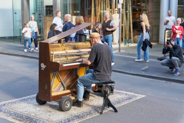  Köln, Almanya 25 Mayıs 2024: Köln şehir merkezinde yaya bölgesinde piyanoya ve oradan geçenlere sahip sokak müzisyeni                              
