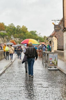   Wuerzburg, Germany  September 26, 2024: Tourists on the old Main Bridge, alte Mainbrcke in Wuerzburg in rainy weather with umbrellas                              clipart