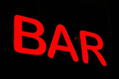   Parlak kırmızı neon tabela bir Alman şehir merkezinde gece yarısı bir bar ilanı veriyor.                              