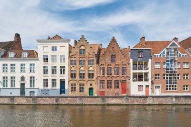 Belçika 'nın eski Bruges kasabasındaki bir kanalın kıyısındaki tarihi ve modern yerleşim yerlerinin birleşimi.                               