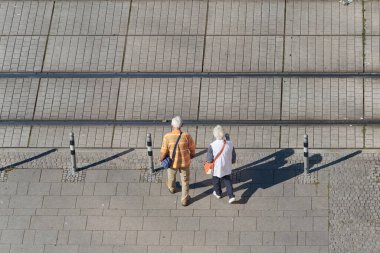    Magdeburg, Almanya 21 Eylül 2024: Almanya 'da Magdeburg şehir merkezinde bir tramvayın raylarından geçen yaşlı bir emekli çift                            