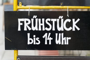  Üzerinde Almanca Frhstck bis 14 Uhr yazan bir kafenin önüne imza atın. Tercümesi: Öğleden sonra ikiye kadar kahvaltı                              