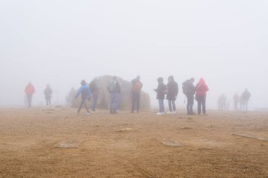 Wernigerode, Almanya 31 Ekim 2024: Sonbaharda sisli bir günde Harz Ulusal Parkı 'nda Brocken' in zirvesinde yürüyüşçüler                               