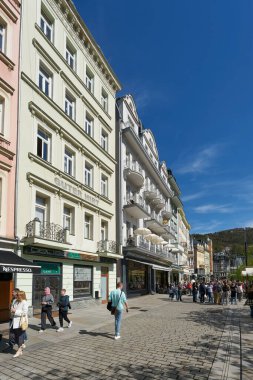 Karlovy Vary, Çek Cumhuriyeti 20 Nisan 2025: Çek Cumhuriyeti 'nin eski Karlovy Vary kentindeki tarihi bir alışveriş caddesinde turistler                               