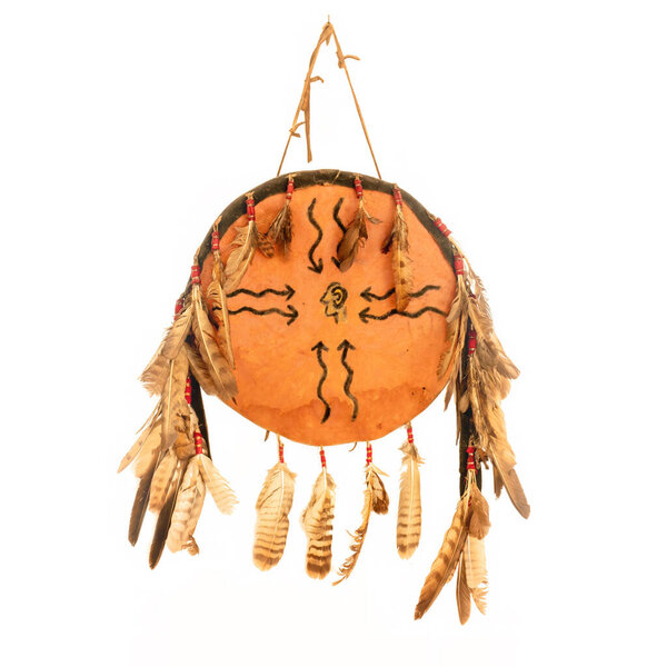Shield of the North American Indians made of rawhide, painted and adorned with feathers, isolated on white