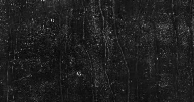 Siyah bir zemin üzerinde bardaktan aşağı akan su damlaları