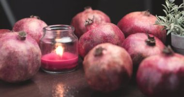 Taze narlarla çevrili nar kokulu mum.