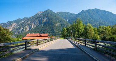 Oberau yakınlarındaki Loisach nehri üzerinde bir köprü. Bavyera manzarası ve turist beldesi. Estergebirge dağlarına bak