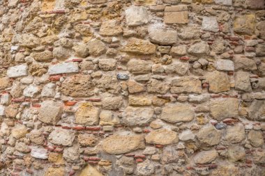 Betondan yapılmış, sıcak bej ve kahverengi renklere sahip doğal taş duvar arkaplanı. tarihi cephe
