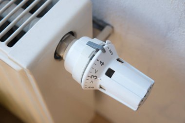 closeup of an old radiator with valve turned on high 