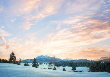 Alp manzaralı gün batımı gökyüzü arka planı Buckelwiesen ve Wetterstein dağları manzarası. Kulübeleri olan kış manzarası, metin için boşluk