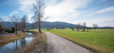 walkway along Jenbach river, view to Auer Weitmoos landscape, near Bad Feilnbach upper bavaria clipart