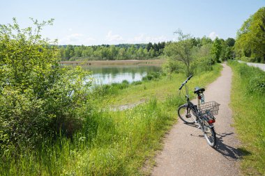 Bisiklet yolu Seehamer Gölü 'nün etrafında. Katlanan bisiklet yolda. Mayıs ayında peyzaj bavyerası