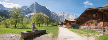 pictorial rural village Eng Almen, tyrolean landscape Karwendel mountains. wooden well, austrian tourist and hiking destination. clipart