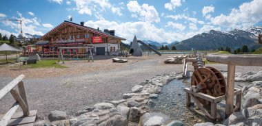 MAYRHOFEN, TYROL, AUSTRIA, 6 Haziran 2024 - Alp restoranı ve ahşap su değirmeni, Penken kablo yolunun üst istasyonu
