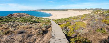 Bordeira sahiline tahta tahta kaldırım, Costa Vicentina, kumlu sörf ve banyo koyu. Carrapateira yakınlarındaki Atlantik kıyıları, Batı Algarve Portekiz.