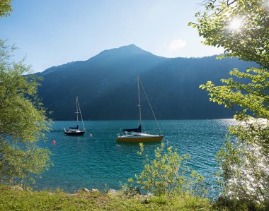 Yaz manzaralı Achensee gölü mavi ve sarı yelkenli, Seeberspitze dağı. manzara austria tyrol.