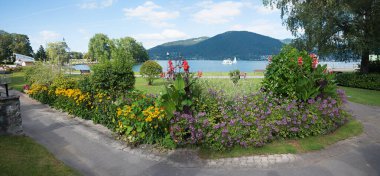 Cennet spa bahçesi Bad Wiessee, Tegernsee Gölü, renkli çiçekli yatak ve yolcu gemisi. Yukarı Bavyera turizm merkezi