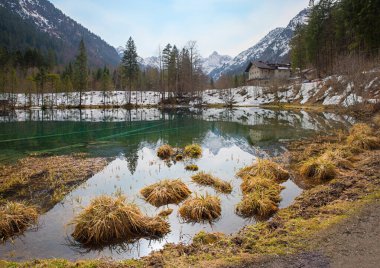 alpine restaurant moor lake Christlessee, allgau alps at early springtime. landscape with some snow clipart