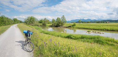 Mangfall nehri boyunca, katlanır bisiklet, nehir kenarındaki kır çiçekleri. Wendelstein Dağı manzaralı, üst Bavyera bahar manzaralı