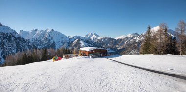 winter scenery at Zwolferkopf mountain, alpine hut and ski run for children and beginners. snowy landscape austrian alps, pertisau with karwendel view. clipart