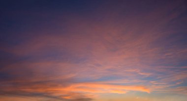 Renkli romantik günbatımı gökyüzü manzarası pembe turuncu ve sarı bulutlar, mor renge dönüşüyor