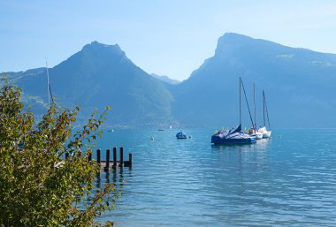 Thunersee Gölü ve Niederhorn Dağı. Suda birkaç yelkenli. Mavi gökyüzü ve güneş ışığı. Peyzaj Bernese Oberland, İsviçre