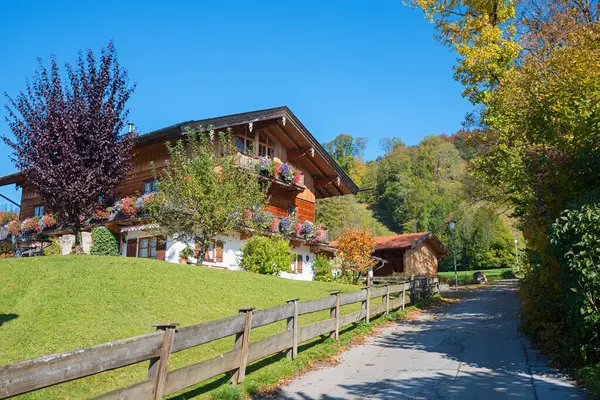 Schliersberg dağına giden yürüyüş yolunun yanında çiçek açan balkon çiçekleri olan güzel bir çiftlik evi. Güz manzarası üst bavyera