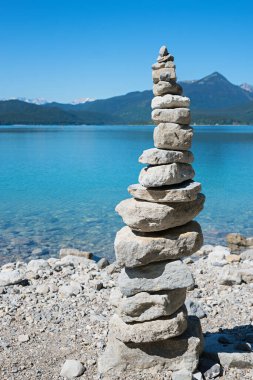Mavi Walchensee Gölü kıyısındaki cairn, Yukarı Bavyera. Mavi gökyüzü olan yaz manzarası.